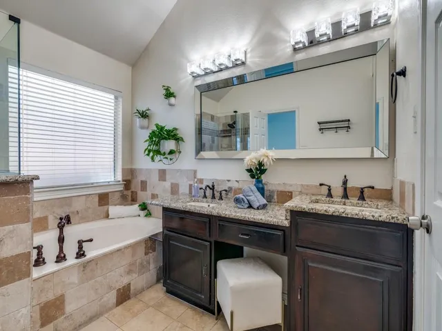 a bathroom with a tub sink and mirror