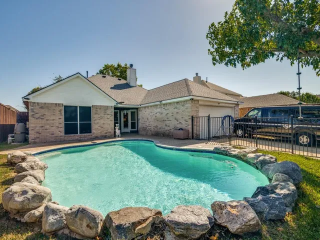 a aerial view of a house with swimming pool and a yard