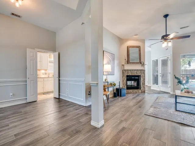 a view of a livingroom with wooden floor a fireplace and window