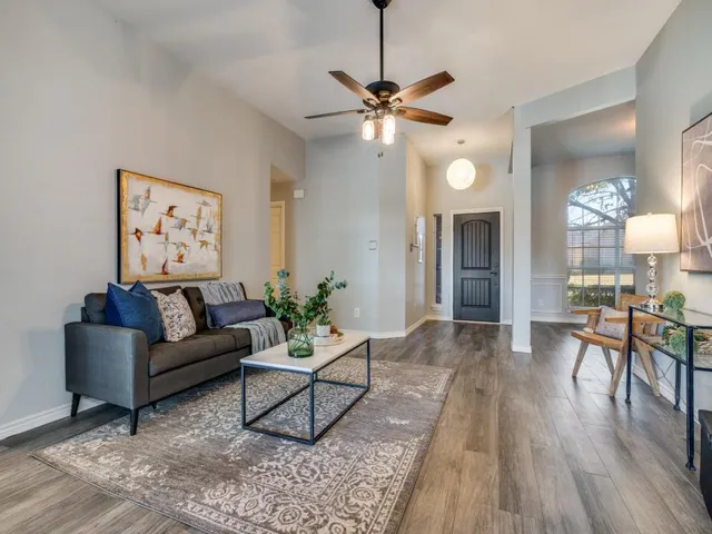a living room with furniture and a wooden floor