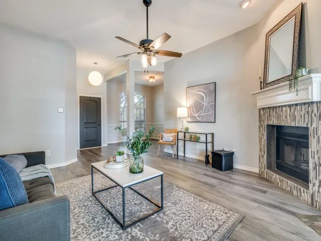 a living room with furniture a fireplace and a chandelier