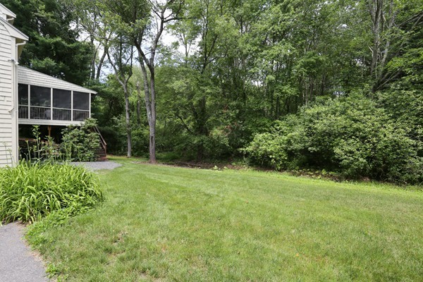 88 Warren Road Sudbury, MA 01776 - Photo 16 of 16 a view of a backyard with potted plants and large trees