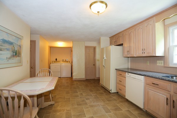 88 Warren Road Sudbury, MA 01776 - Photo 9 of 16 a kitchen with stainless steel appliances granite countertop a sink a stove a refrigerator a microwave oven with white cabinets and wooden floor