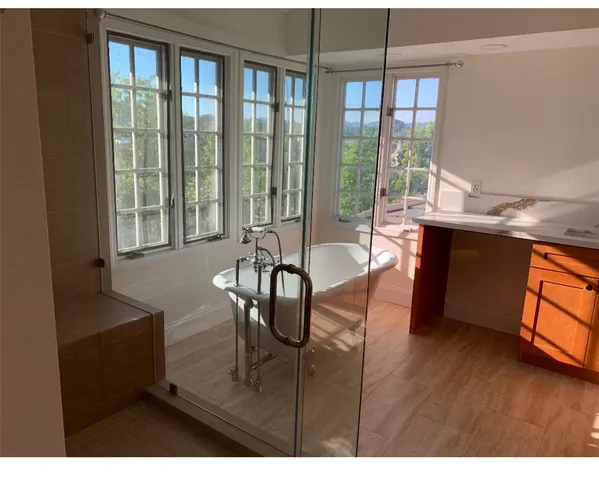 a living room with furniture a large window and wooden floor