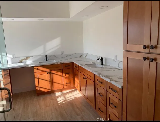 a kitchen with stainless steel appliances granite countertop a sink a stove and a wooden floors