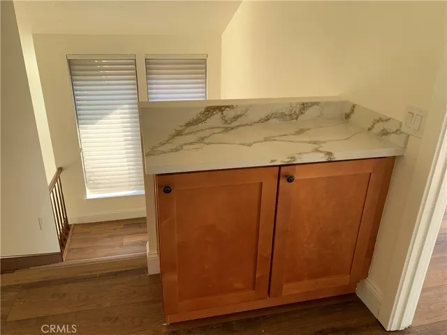 a view of an empty room with wooden floor and a fireplace