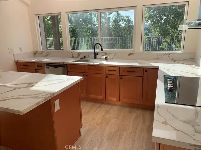 a kitchen with stainless steel appliances granite countertop a sink a stove and a microwave