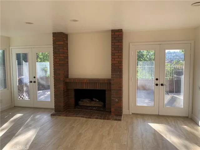 a view of an empty room with glass door and wooden floor