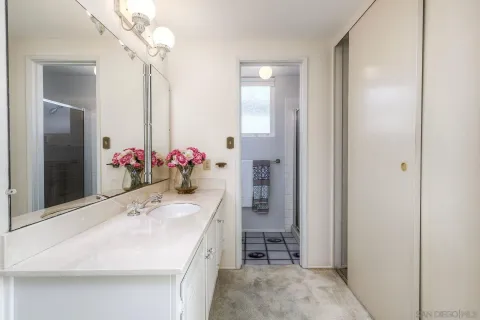 a bathroom with a granite countertop sink a toilet and a mirror