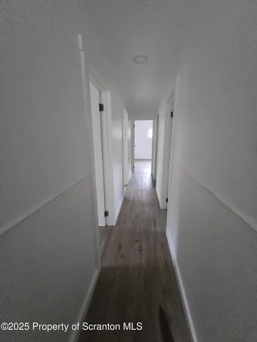 a view of hallway with wooden floor