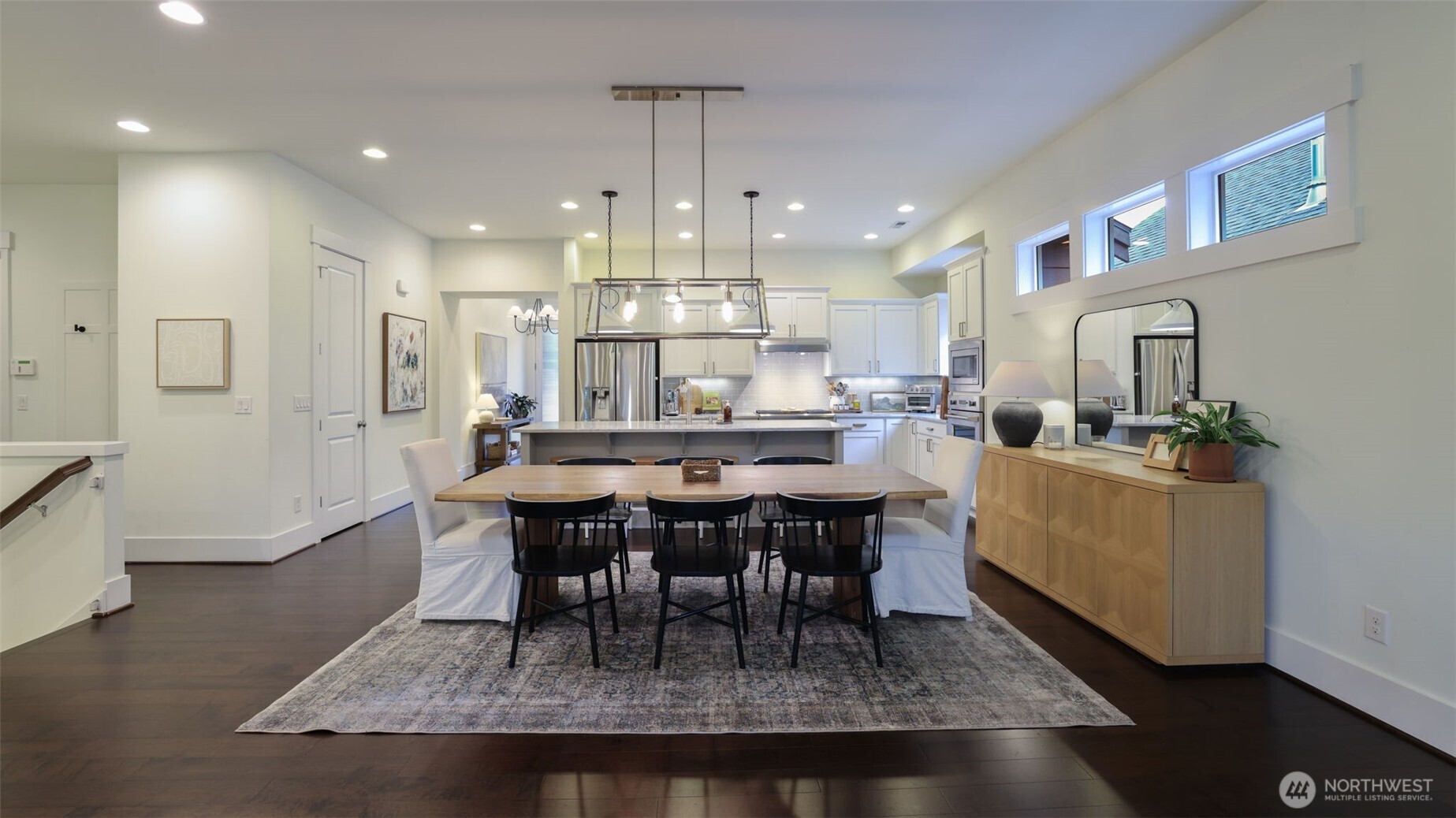 629 Field Place Northeast Renton, WA 98059 - Photo 18 of 37 a dining room with kitchen island a dining table wooden floor stainless steel appliances and kitchen view
