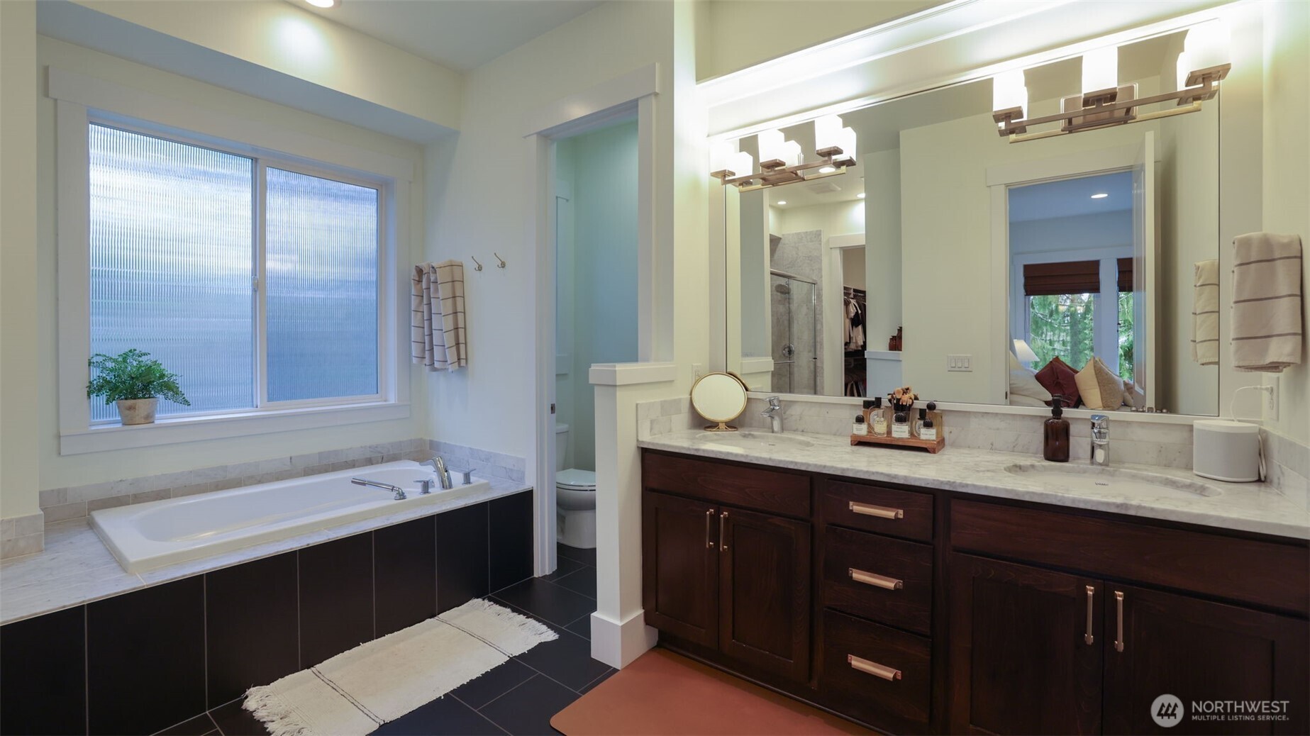 629 Field Place Northeast Renton, WA 98059 - Photo 21 of 37 a bathroom with a double vanity sink a large mirror a bathtub and shower