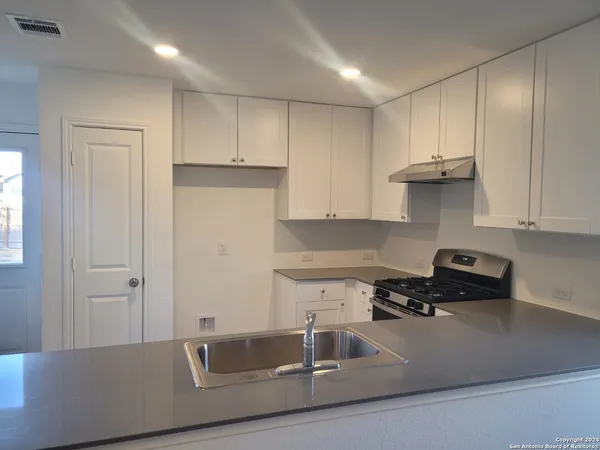 a kitchen with stainless steel appliances granite countertop a sink a stove and a refrigerator