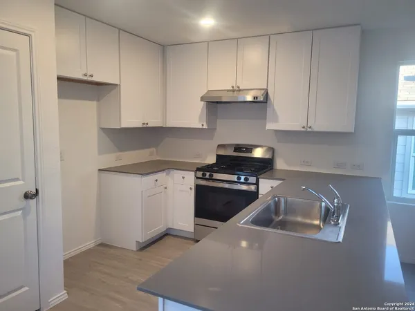 a kitchen with a sink stove and cabinets