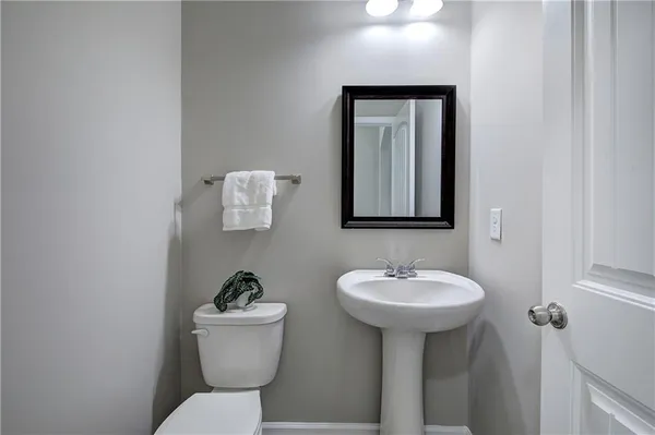 a bathroom with a toilet a sink and mirror