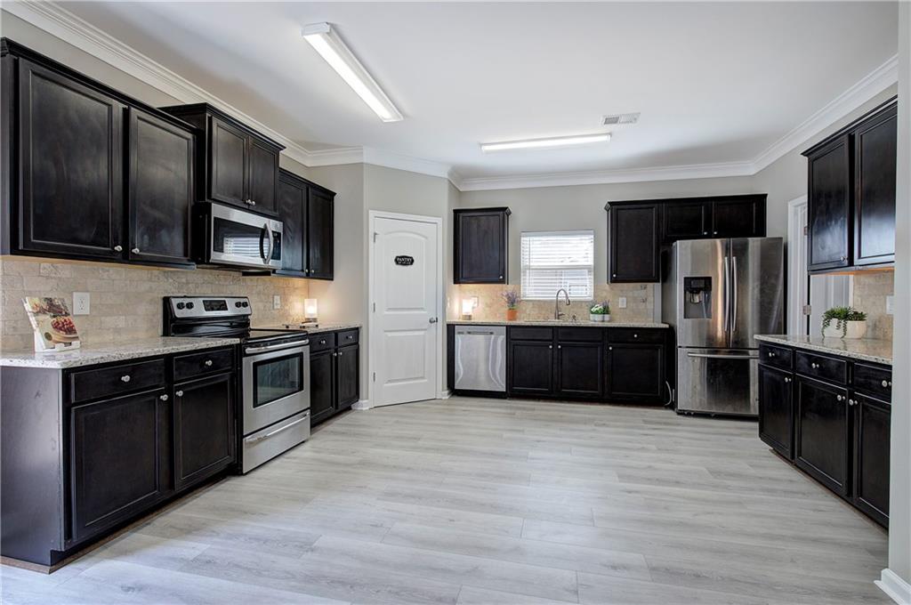 4 Timberland Trace Court Dallas, GA 30157 - Photo 8 of 53 a large kitchen with stainless steel appliances wooden cabinets and a wooden floor