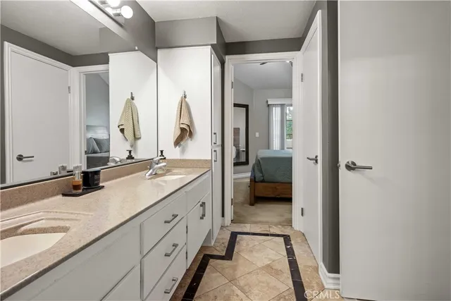 a spacious bathroom with a double vanity sink a mirror and a shower