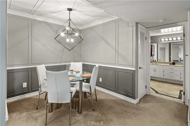 a kitchen with stainless steel appliances a sink a stove a refrigerator cabinets and a dining table