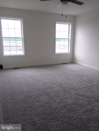 an empty room with a window and a ceiling fan