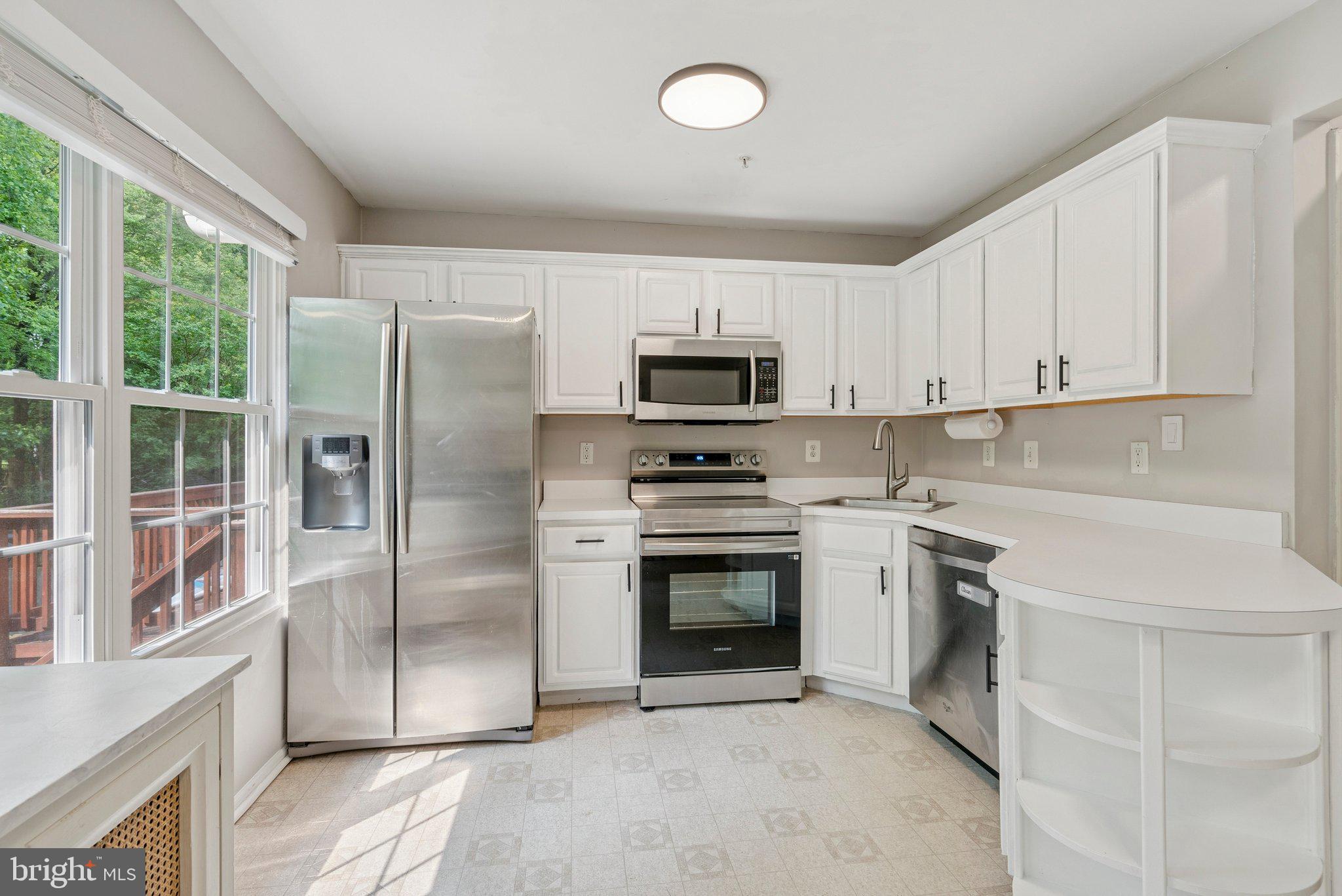 3559 Orchard Shade Road Randallstown, MD 21133 - Photo 5 of 18 a kitchen with stainless steel appliances granite countertop a refrigerator a stove a sink and a microwave