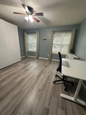 a view of workspace with wooden floor windows