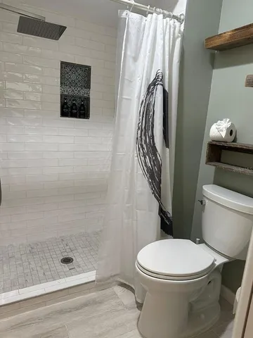 a bathroom with a shower a toilet and a shower