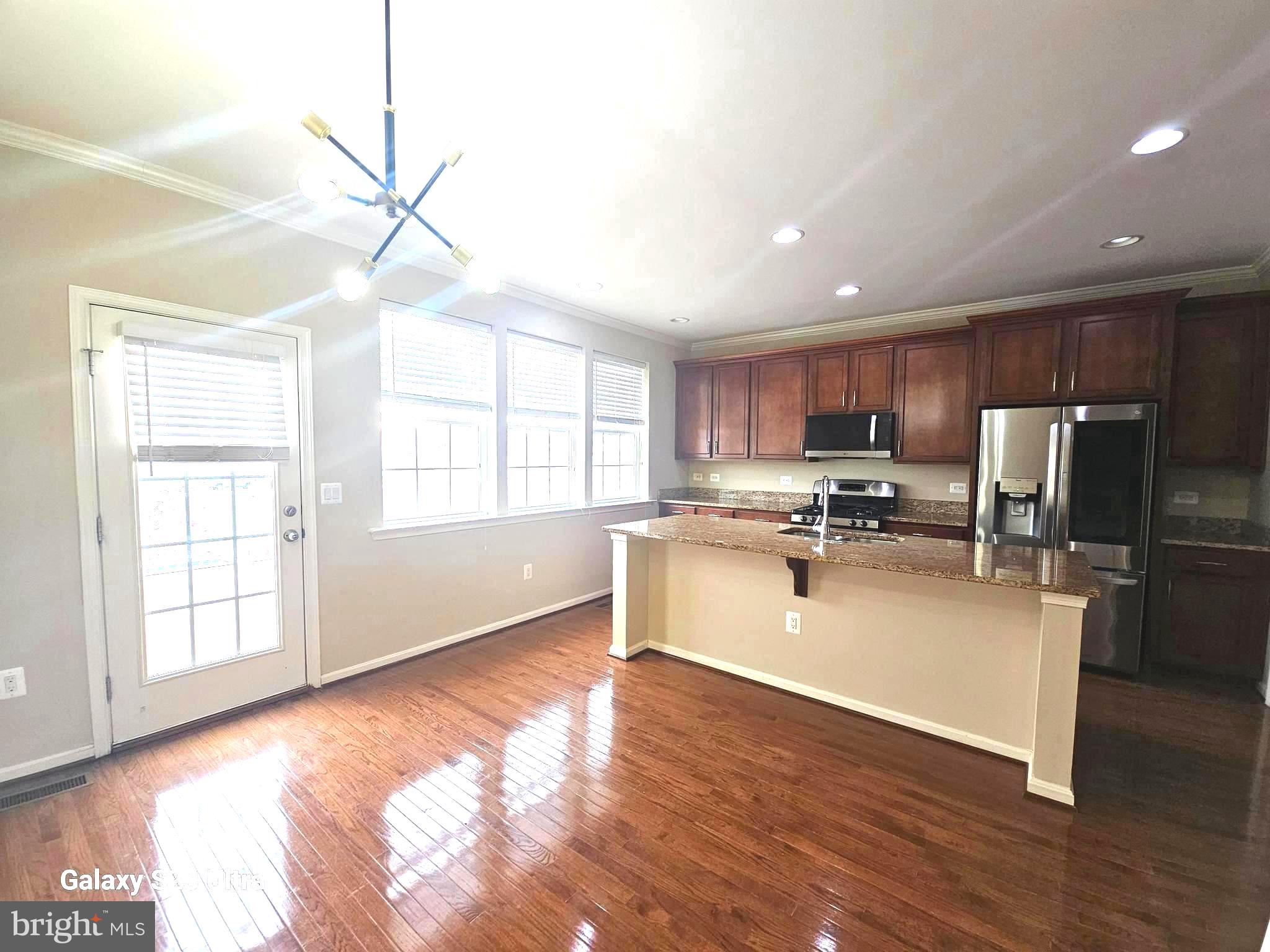25634 Pleasant Valley Road Chantilly, VA 20152 - Photo 12 of 40 a kitchen with stainless steel appliances granite countertop a refrigerator a sink dishwasher a stove and white cabinets with wooden floor