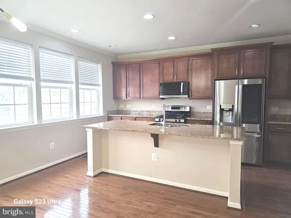 a kitchen with a refrigerator and a stove top oven