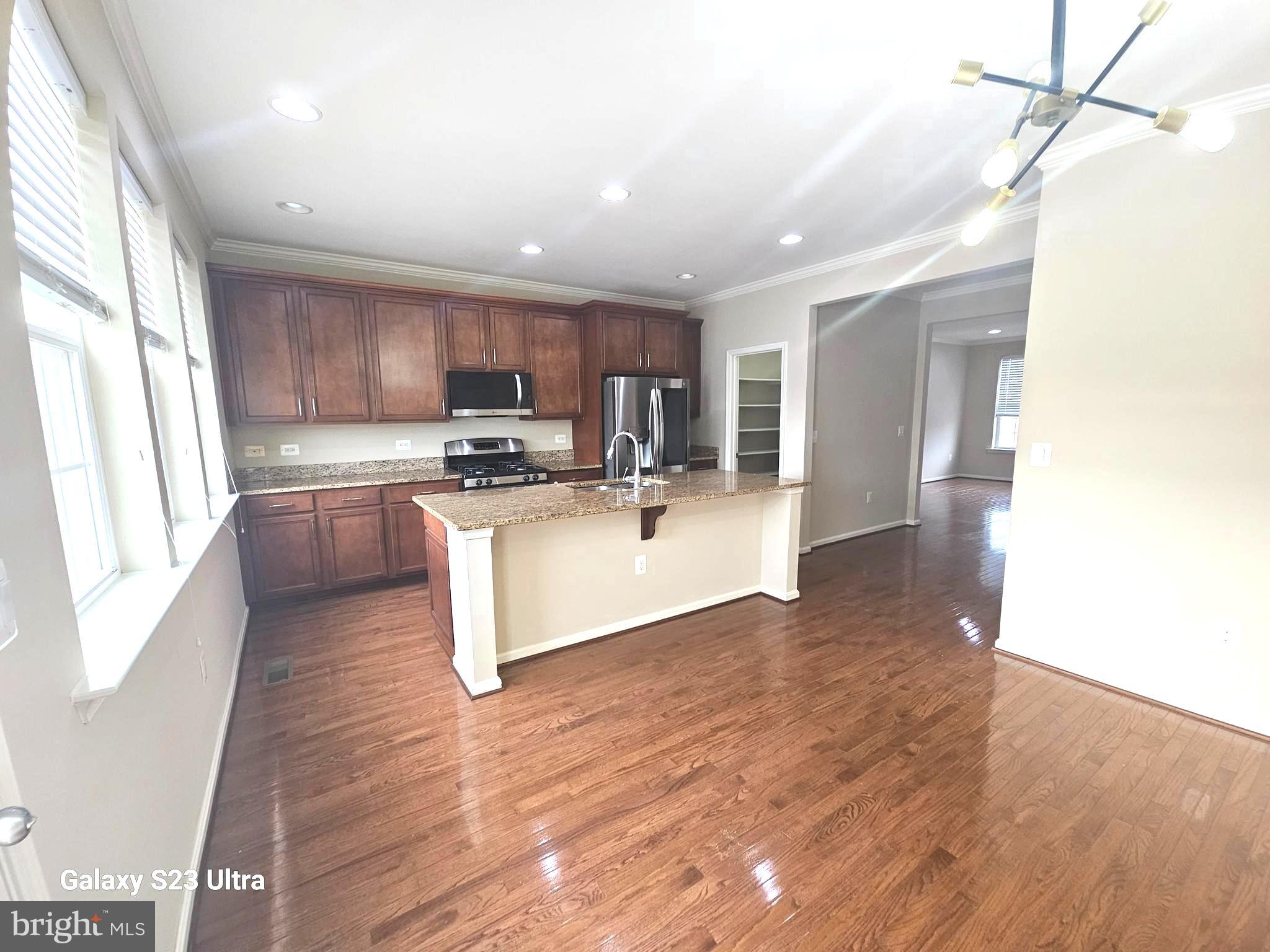 25634 Pleasant Valley Road Chantilly, VA 20152 - Photo 15 of 40 a kitchen with stainless steel appliances granite countertop a sink a stove top oven a counter space and cabinets