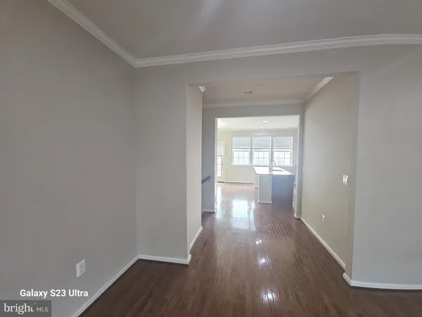 a view of a room with wooden floor and a window