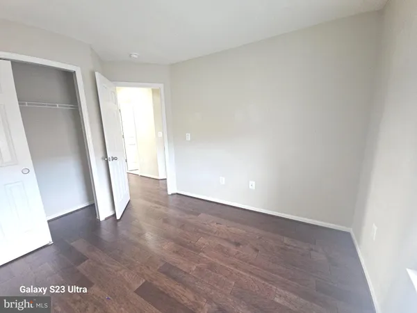 an empty room with wooden floor and entrance