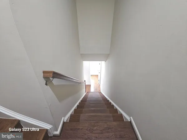 a view of a hallway with wooden floor and entryway