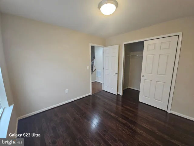 a view of an empty room with wooden floor