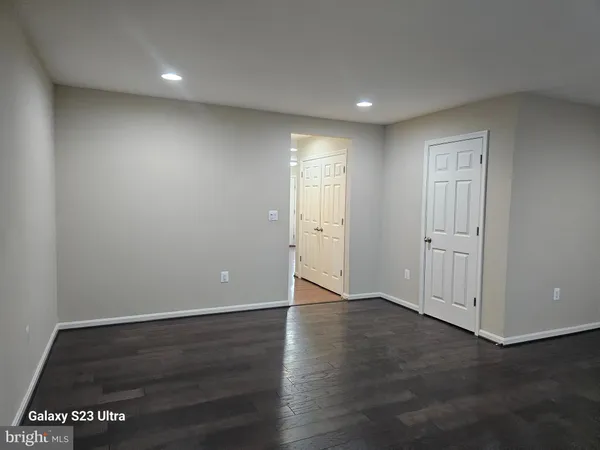 an empty room with wooden floor & windows