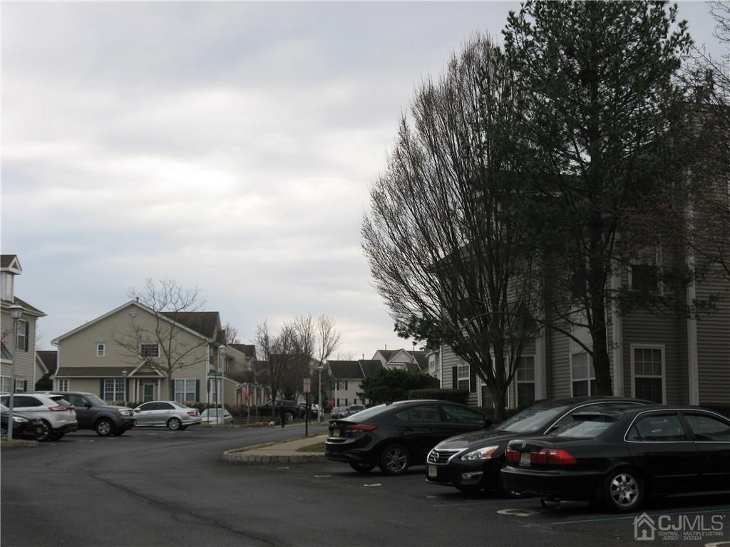 1707 Ridgeview Court, Unit 1707 Sayreville, NJ 08859 - Photo 3 of 3 a view of road with card parked on side and retail shops