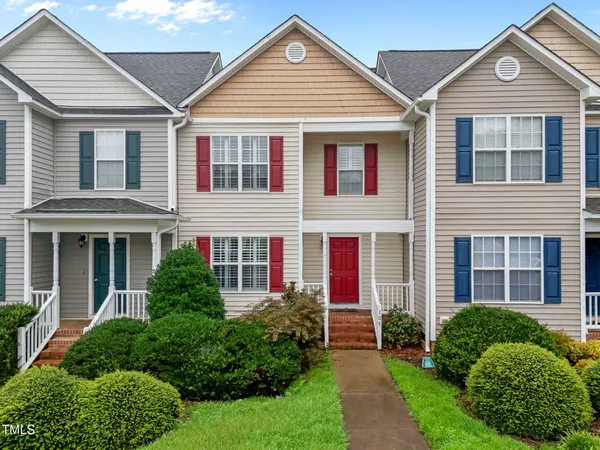 a front view of a house with a yard and plants