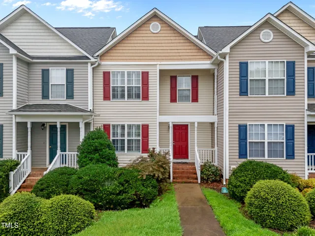 a front view of a house with a yard and plants