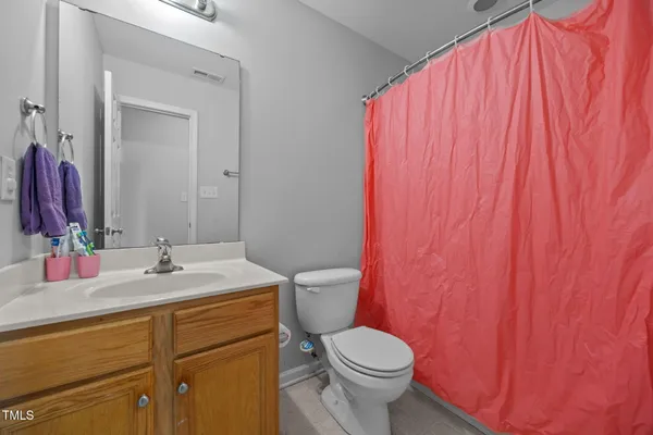 a bathroom with a sink a toilet and shower curtain