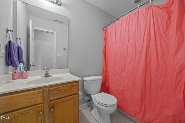 a bathroom with a sink a toilet and shower curtain