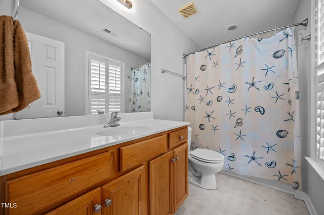 a bathroom with a granite countertop sink a toilet and a mirror