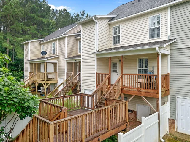 a view of a house with wooden deck and furniture