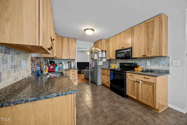 a kitchen with stainless steel appliances granite countertop a stove sink microwave and cabinets