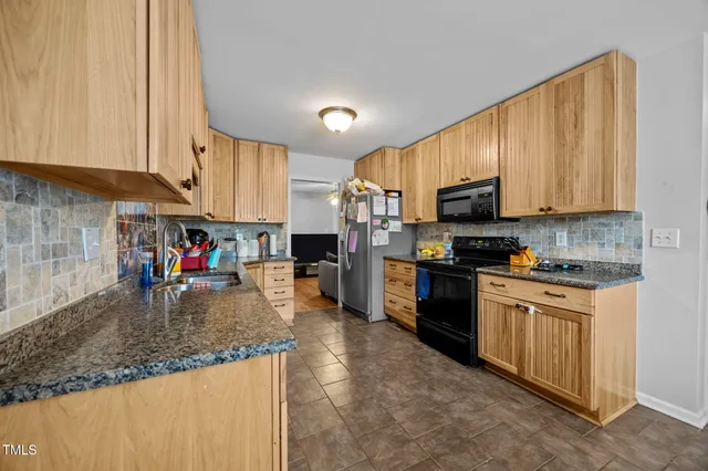 a kitchen with stainless steel appliances granite countertop a stove sink microwave and cabinets