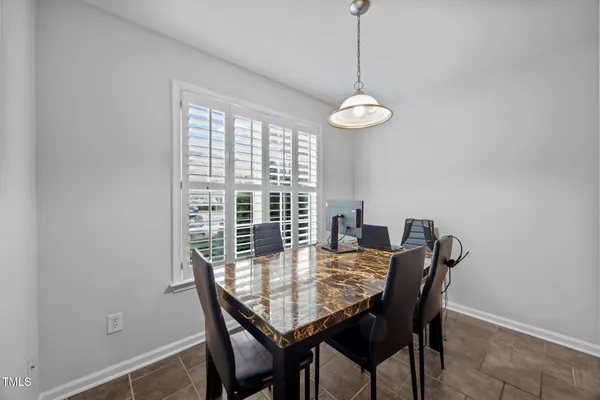 a view of a dining room with a table and chairs