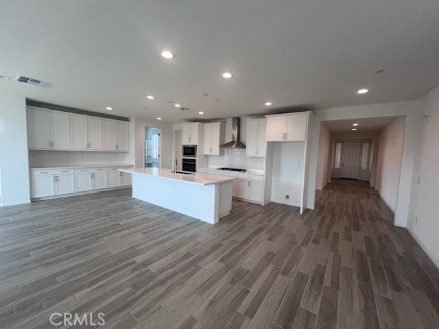 24261 Arroyo Drive Menifee, CA 92584 - Photo 11 of 24 a large kitchen with a center island wooden floor stainless steel appliances and cabinets