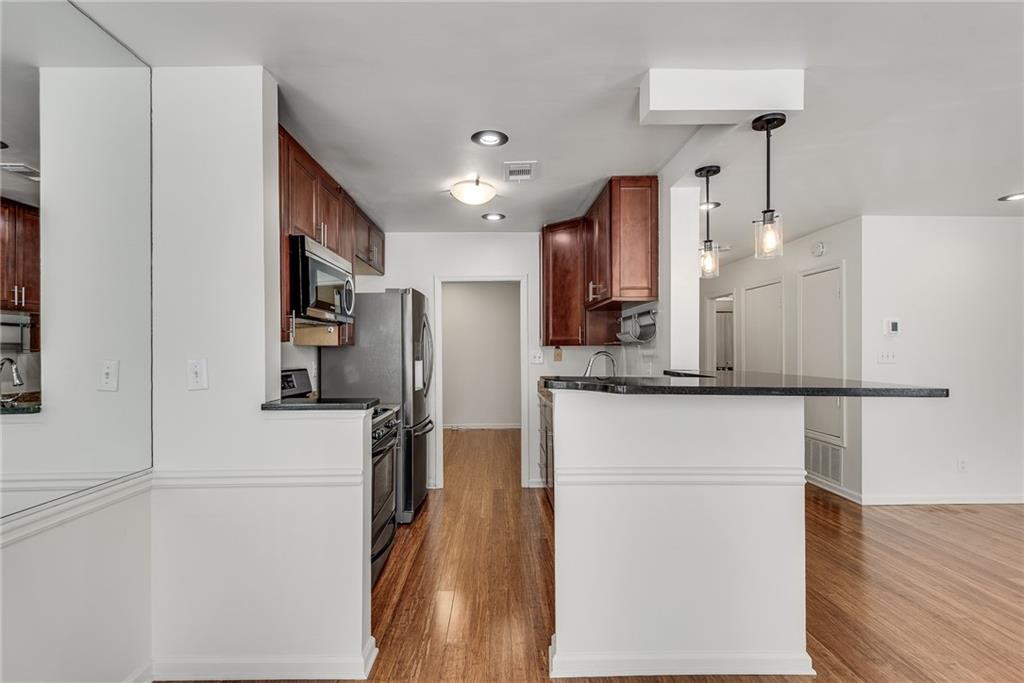 244 13th Street Northeast, Unit 118 Atlanta, GA 30309 - Photo 13 of 48 a kitchen with stainless steel appliances a refrigerator sink and cabinets