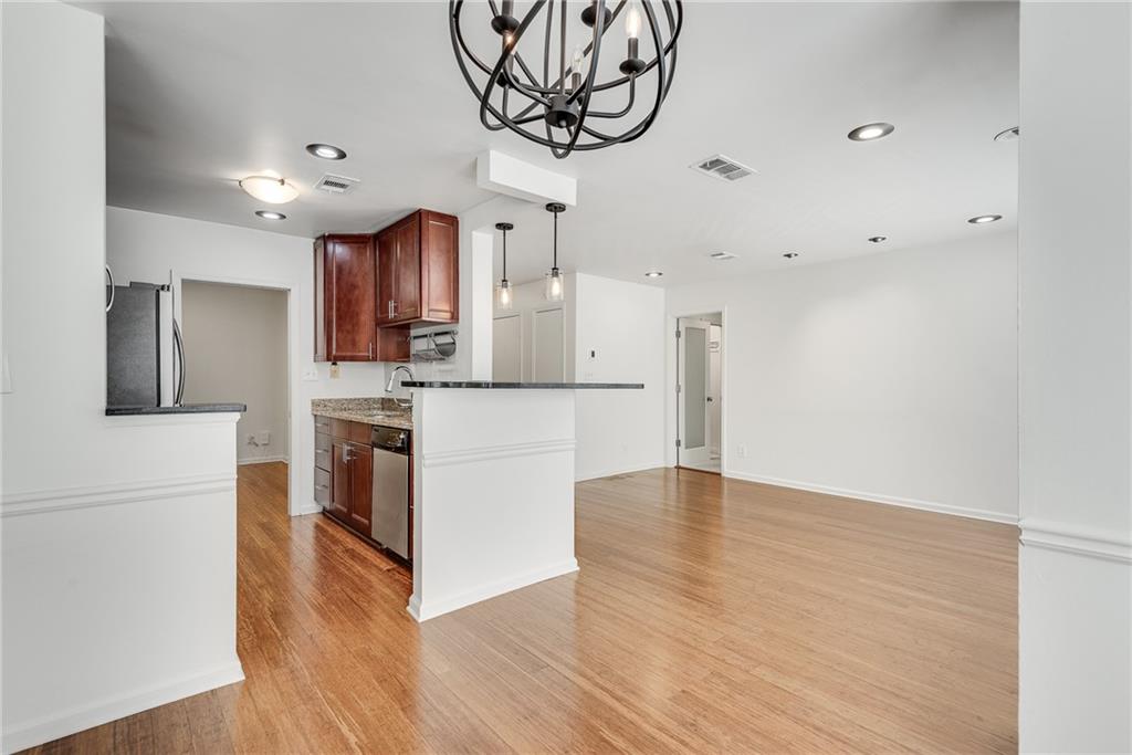244 13th Street Northeast, Unit 118 Atlanta, GA 30309 - Photo 18 of 48 a kitchen with stainless steel appliances granite countertop a refrigerator a stove and a wooden floors