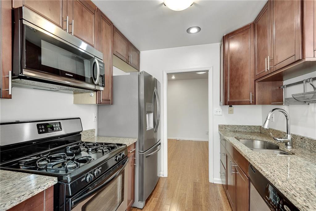 244 13th Street Northeast, Unit 118 Atlanta, GA 30309 - Photo 10 of 48 a kitchen with granite countertop stainless steel appliances and wooden cabinets