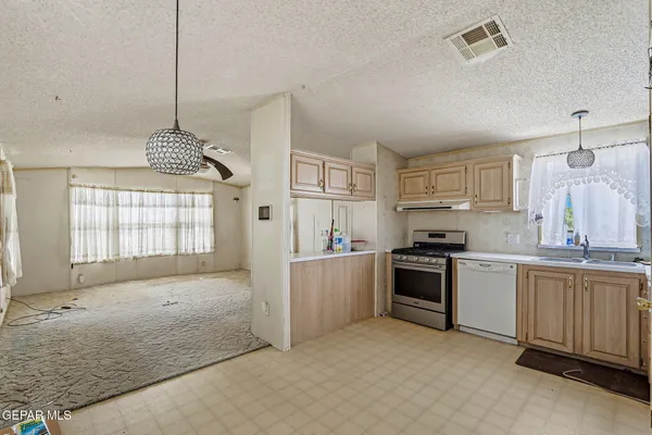 a kitchen with kitchen island granite countertop a stove sink and cabinets
