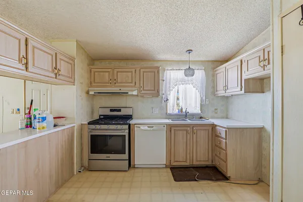 a kitchen with a stove top oven and cabinets